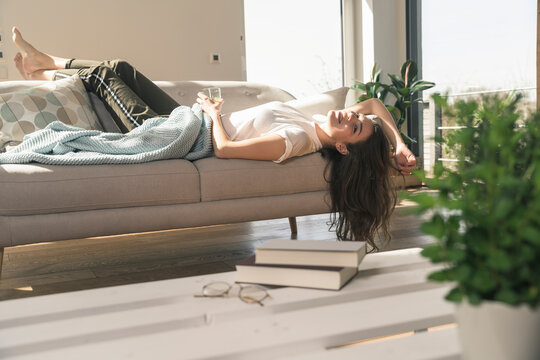 Relaxed young woman lying on couch