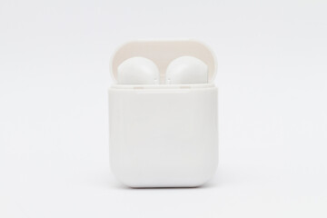 Close up on portable bluetooth earbuds on a neutral background, no people are visible. - 632044099
