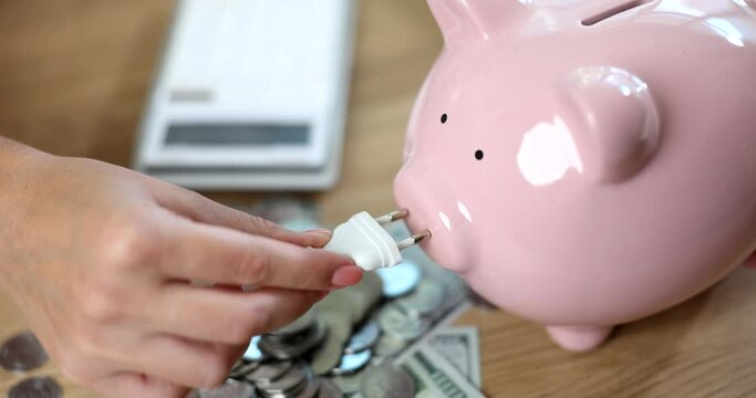 Fork in hand and piggy bank with coins and calculator. Energy saving