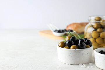 Olives in bowls and jar on white background, space for text