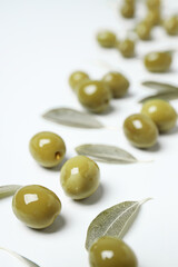 Olives and olive tree leaves on white background