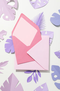 Paper purple tropical leaves on a light background, with pink writing