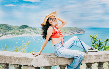 Happy tourist woman in hat on a viewpoint. Smiling vacationer girl in a viewpoint. Travel and tourism promotion concept