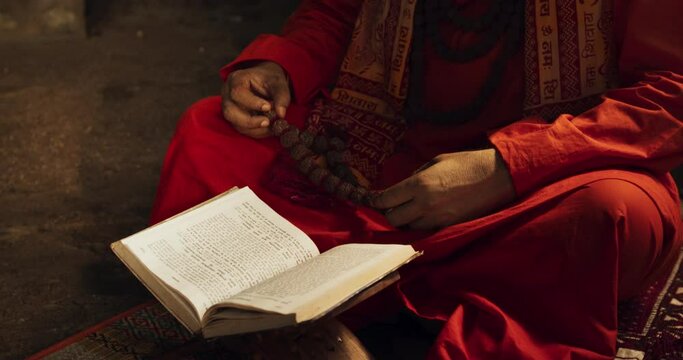 Slow Motion Portrait of Old Indian Monk Reading a Book in an Ancient Temple. Senior Guru Getting Wisdom from Sacred Texts, Humbly Chating Sacred Mantras, Showing Devotion and Love in Worship