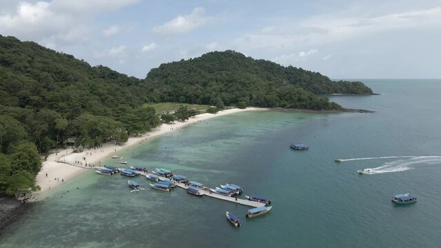 Aerial: Tourists on tour boat pier of small isle in Strait of Malacca