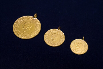 full, half and quarter Turkish gold coins side by side on a dark navy blue background