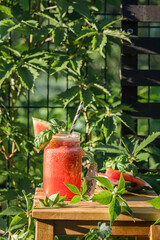 watermelon smoothie on a wooden table outside