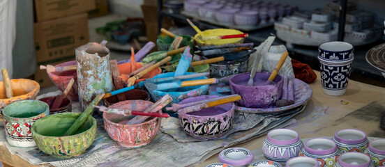 Workstation, with paints and brushes, in an artisan ceramics factory in Fes in Morocco.