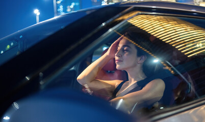 Fototapeta na wymiar Beautiful young woman driving car at night.
