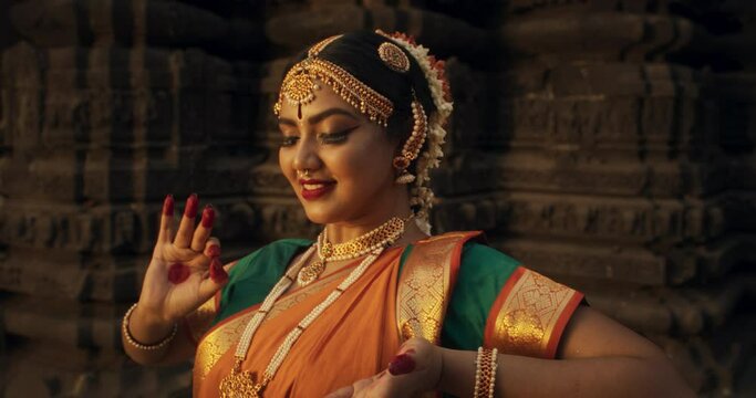 Zoom Out Portrait of an Indian Female Dancer Displaying Symbolic Gesture with Expressive Face, Using Folkloric Dance to Tell a Story. Girl in Traditional Sari Showcasing the Art of Mudras Movement