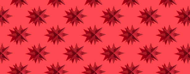 Glitter red or magenta stars decoration pattern on red background with shadows. Red festive background. Winter minimal holiday postcard. New Year or Christmas minimal flat lay concept. Banner, header