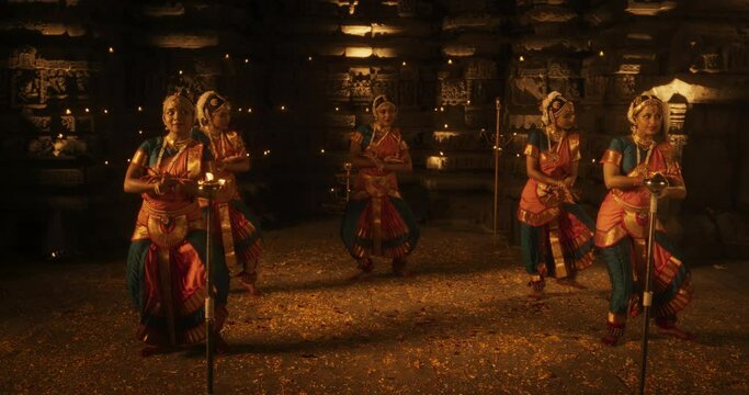 Enchanting Slow-Motion Portrayal Showcases a Lively Ensemble of Indian Women Joyfully Dancing Traditional Folk Inside an Empty Historic Temple. Vibrant and Mesmerizing South Asian Cultural Festivity
