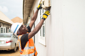 african electrician working on connections at a home