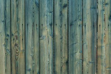 Wooden timber plank fence painted with semi-transparent green protective paint