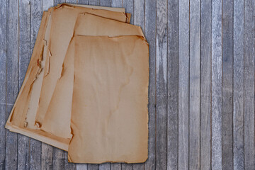 Closeup wooden desk with stack of old paper torn off edges for message, designer text, empty blank...