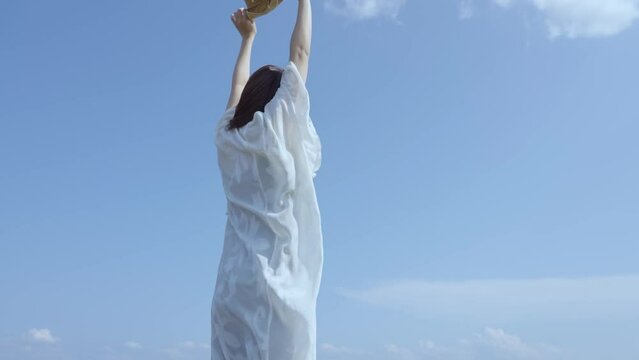 快晴の空の下でリラックスした表情を見せる若い女性