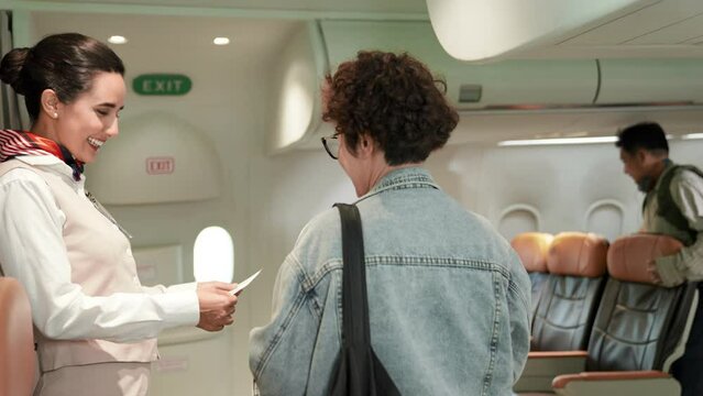 Beautiful and attractive asian flight attendant staff smiling. Passenger giving passport with boarding pass to air hostess woman check on airplane. Cabin crew or stewardess occupation concept.