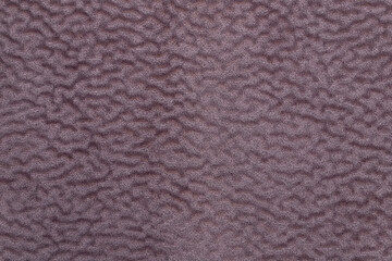 Plush soft velor fabric with villi. Shaggy fabric material with purple structural waves. Background from upholstery fabric for upholstery close-up.
