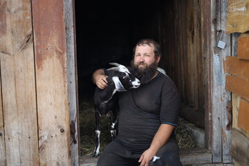 farmer with a beard with an Anglo-Nubian goat