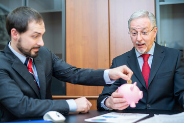 Man putting money in a piggy bank