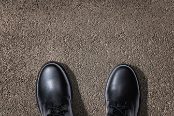 Concept - a man stands on a textured asphalt surface. View from above. On a clean place, you can put a motivational inscription.