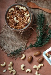 a healthy granola bar for a snack lies on a wooden table along with nuts