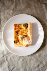 Sliced traditional french open quiche pie with cheese and broccoli