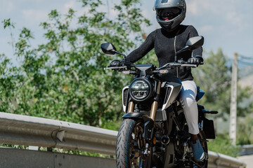 Fototapeta na wymiar Female biker on motorcycle in countryside