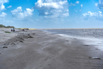 Sand fegt über einen Strand auf Langeoog