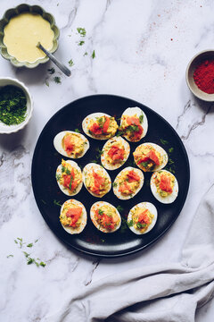 Homemade deviled eggs with salmon on a black background.