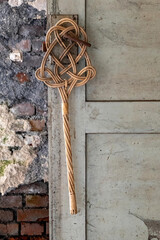 an old carpet beater on a door in a lost place