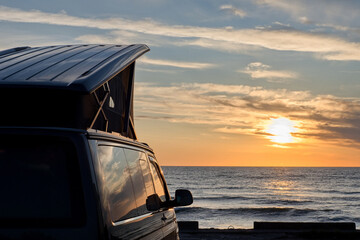 Camper van is stand on camping place on sea coast. Beautiful seascape. © Igor