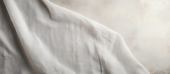Copy space is available on a light grunge stone background for a pure washed linen cloth. This natural washed linen fabric is placed on a stone tile surface.