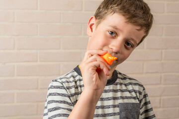 boy of school age writes in the air with an orange marker