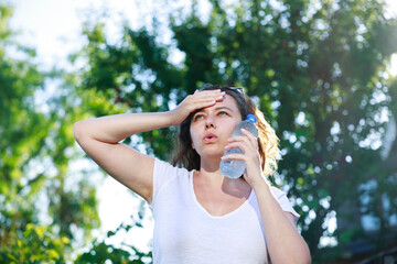 Young woman having hot flash and sweating in a warm summer day