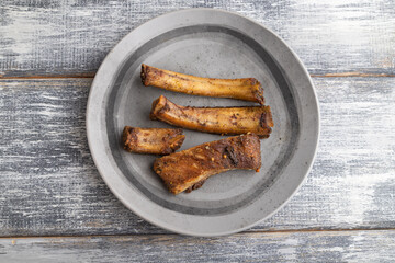pork ribs on a wooden plate on a gray. Top view.