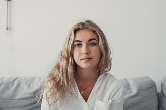 Positive Serious Millennial Model Girl Home Female Head Shot Portrait. Beautiful Young Adult Caucasian Woman Looking At Camera, Posing In Apartment. Front Profile Picture.