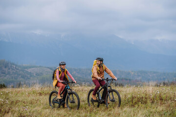 Happy couple at bicycles, in the middle of autumn nature. Concept of a healthy lifestyle.
