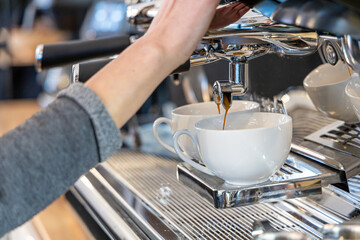 Barista coffee service concept.Barista women using coffee machine to make coffee in cafe