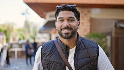 African american man smiling confident standing at coffee shop terrace