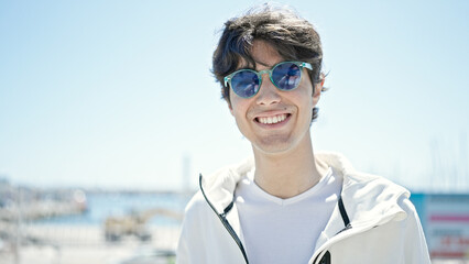 Young hispanic man smiling confident wearing sunglasses at seaside