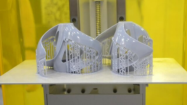 Printed models on 3D printer close-up. Objects printed on photopolymer sla 3D printer from liquid photopolymer resins on printing platform. Modern progressive additive technology. 3D printer printing