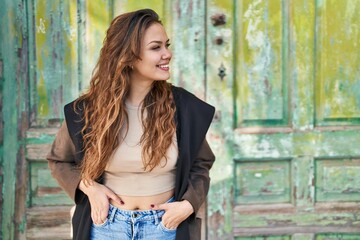 Fototapeta premium Young beautiful hispanic woman smiling confident looking to the side at street