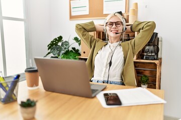 Young blonde woman business worker agent relaxing with hands on head at office