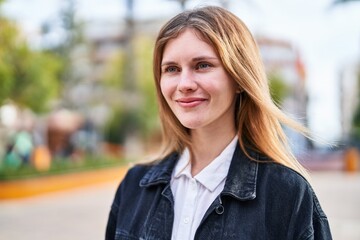 Young blonde woman smiling confident looking to the side at park