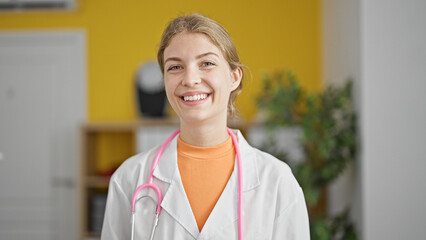Young blonde woman doctor smiling confident standing at clinic
