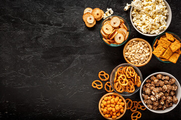 Bowls with different salty snacks for party. Fast food background