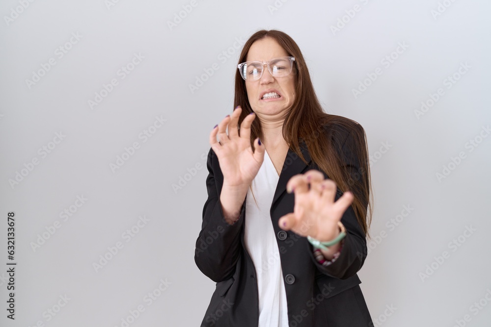 Poster beautiful brunette woman wearing business jacket and glasses disgusted expression, displeased and fe