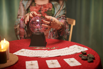 Hands of seer touching crystal ball when trying to predict future