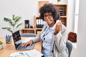 Black woman with curly hair wearing call center agent headset at the office doing italian gesture...